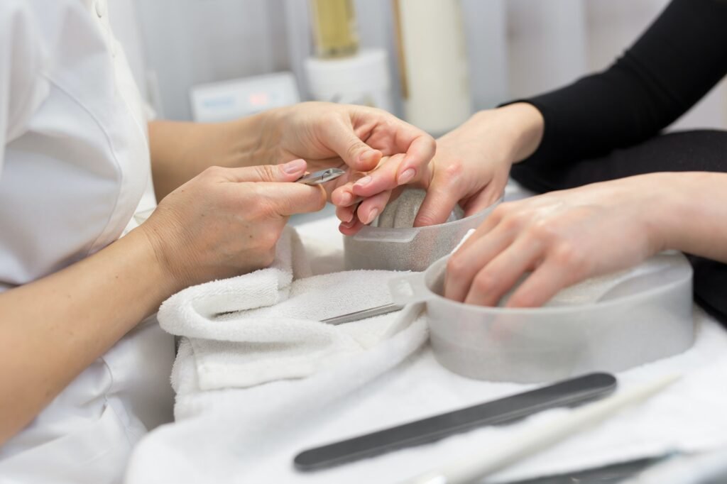 Nail Salon. Closeup Of Female Hand With Healthy Natural Nails Getting Nail Care Procedure. Hands